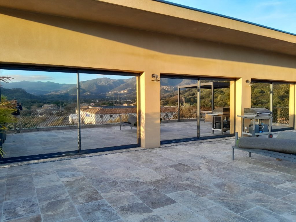 Baie vitrée aprés pose des films solaires Chromés anti chaleur et U.V, Vue en extérieur,à Saint Florent