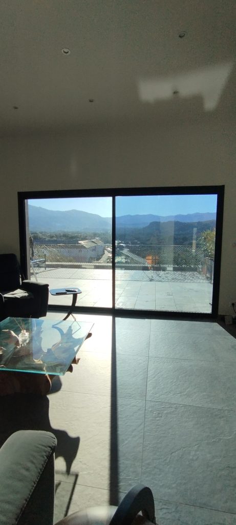 Baie vitrée aprés pose des films solaires Chromés anti chaleur et U.V, Vue en intérieur avec et sans film,à Saint Florent