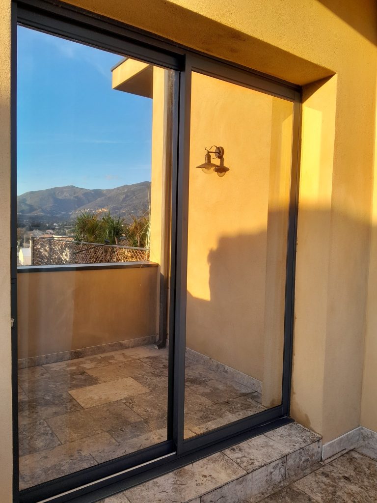 Baie vitrée aprés pose des films solaires Chromés anti chaleur et U.V, Vue en extérieur,à Saint Florent