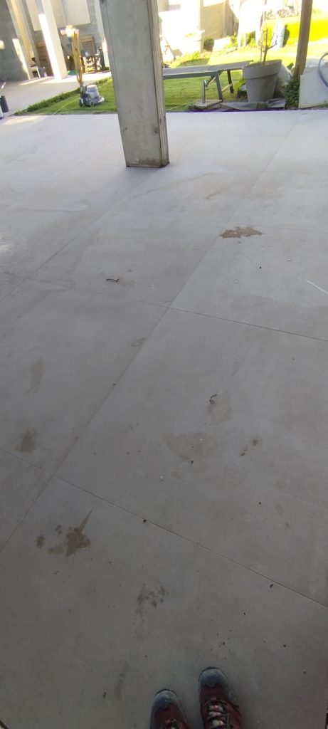 Photo d'une terrasse en carrelage avant nettoyage intensif, présence de laitance et de marque de colle, intervention faite à Furiani