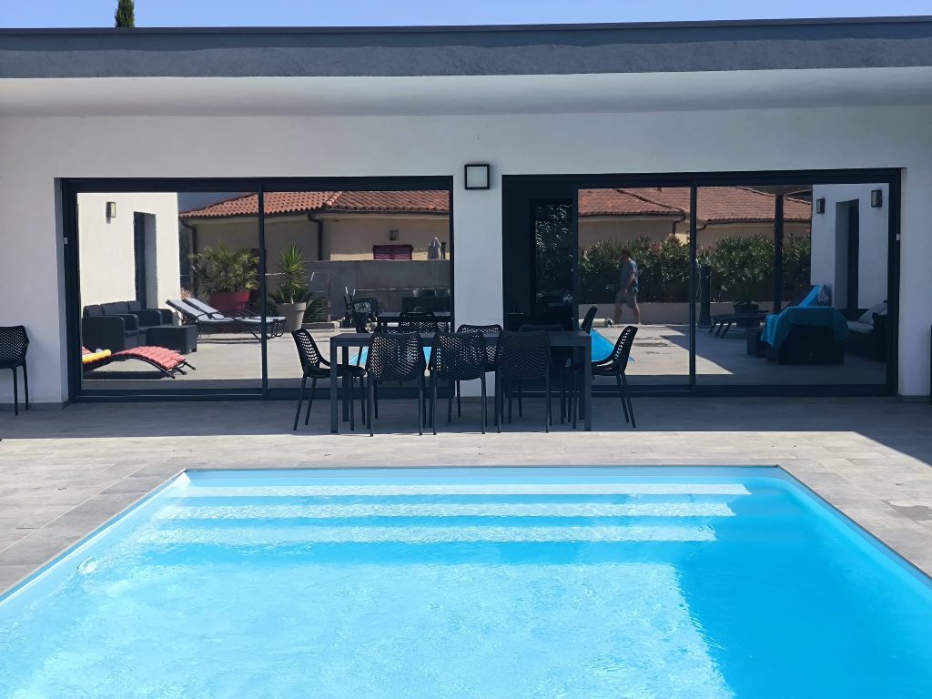 Baie vitrée aprés pose des films solaires Solar Screnn Chromés anti chaleur et U.V, vue en extérieur, à Oletta