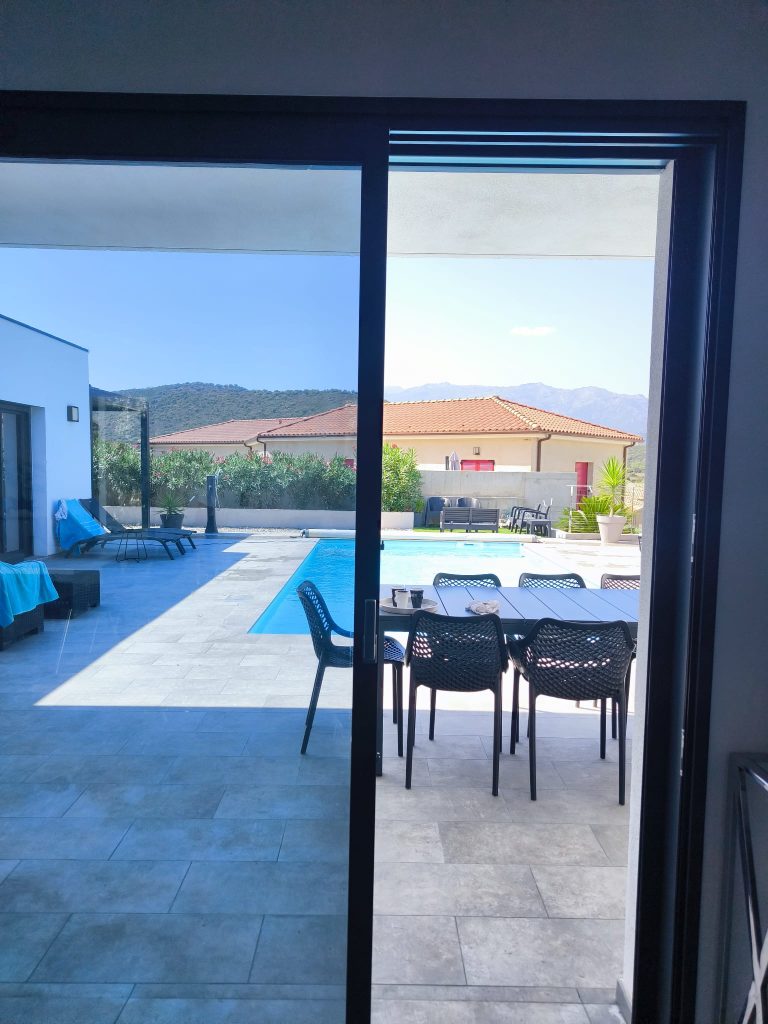 Baie vitrée aprés pose des films solaires Solar Screnn Chromés anti chaleur et U.V, Vue en intérieur,à Oletta