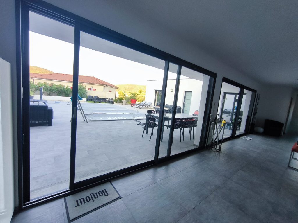 Baie vitrée avant pose des films solaires Chromés anti chaleur et U.V, Vue en intérieur,à Oletta