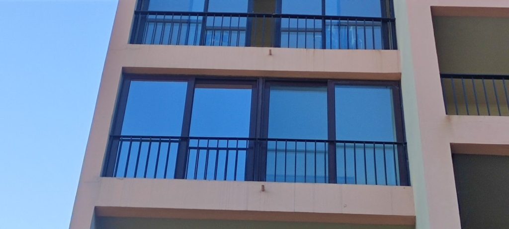 Vitrages avec films anti-chaleur effet miroir sur immeuble à Ajaccio par Caps-2B