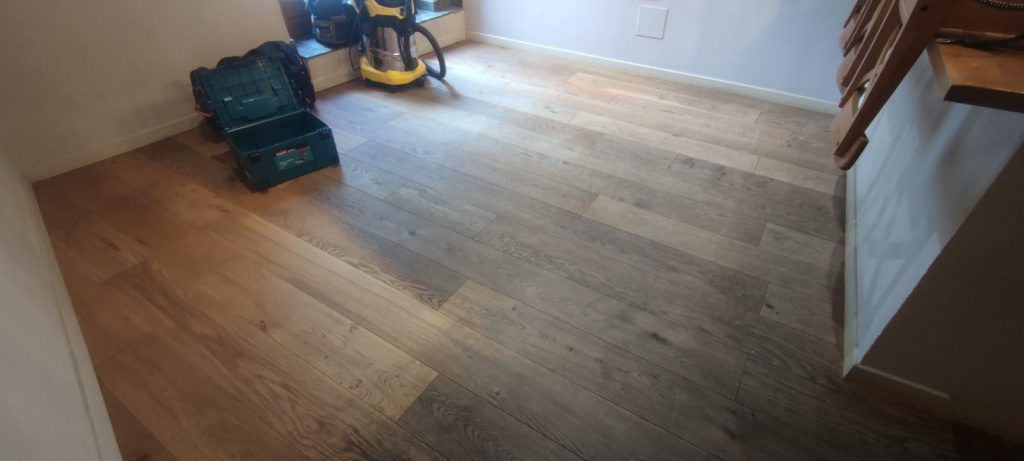 Parquet chêne avant rénovation présentant zones sombres et usées à Bastia par Caps-2B