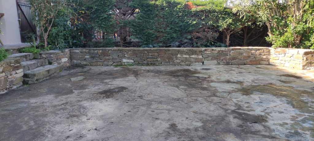 État initial d'une terrasse en pierre naturelle avant décapage à Saint-Florent par Caps-2B