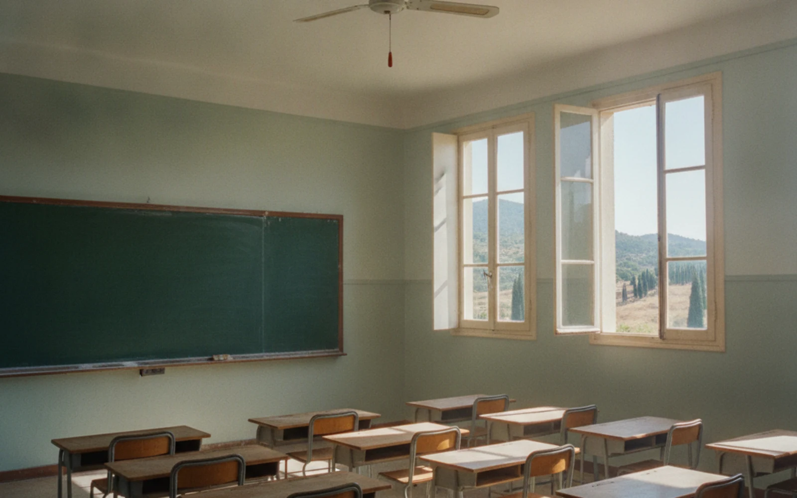 Salle de classe vide en Corse avec une grande façade vitrée traitée en film solaire, lumière douce sans éblouissement, ambiance fraîche